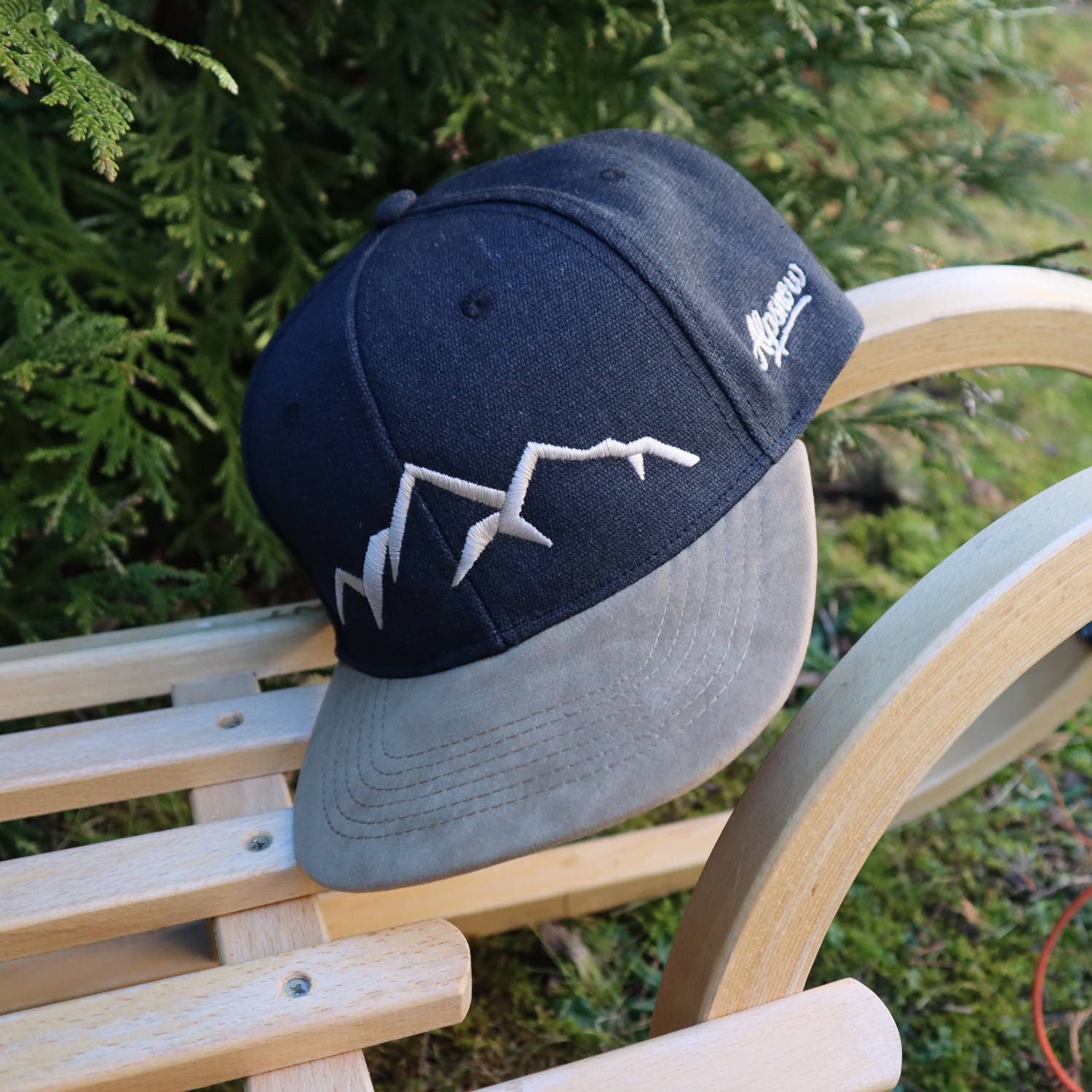 Alpsnow Rustikale Cap Berge Vintage Black mit beigem Stick und Schirm auf einem Holzschlitten