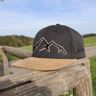 Anthrazitfarbene rustikale Alpsnow Cap mit massivem schwarzen 3D-Bergstick und beiger Umrandung